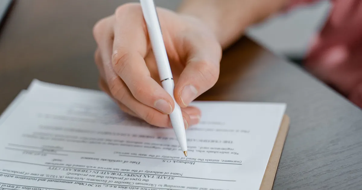 A person completing official application paperwork